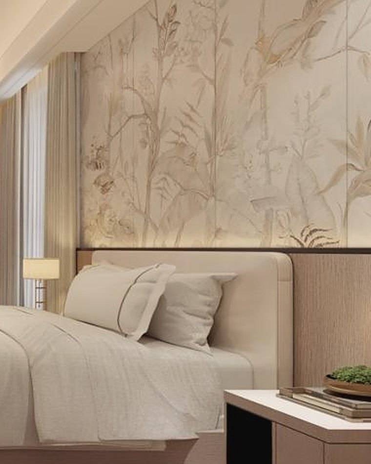 Upholstered headboard and bedside lamp against a hand-painted botanical wall panel
